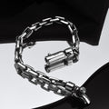 Silver chain bracelet on a reflective surface with a dark background