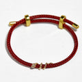 BoxUnboxed 18k solid gold snake bracelet with diamond eyes on red string cord. Adjustable fit.