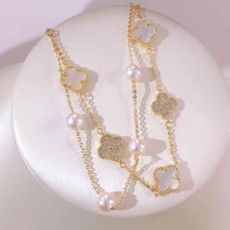 BoxUnboxed gold-plated double-layer bracelet with white pearls and clover charms.