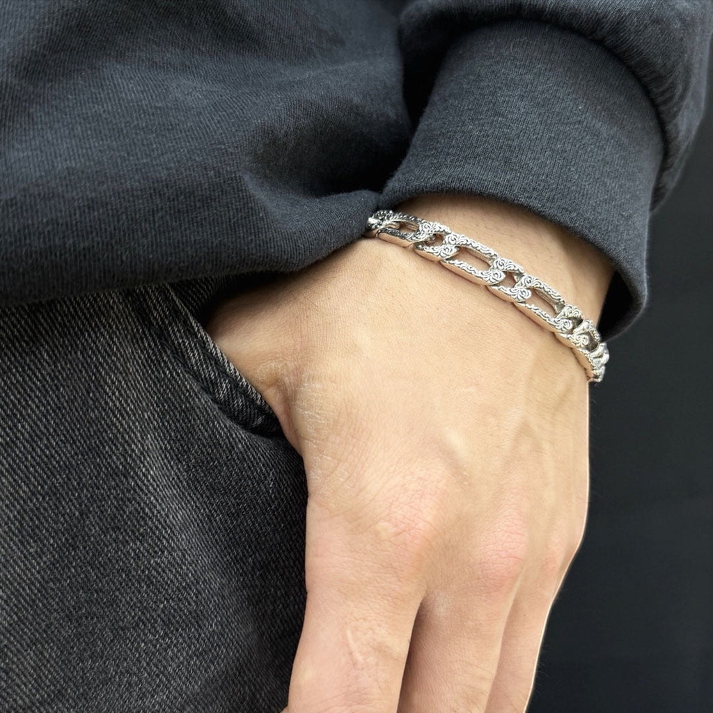 BoxUnboxed Sovereign Imperial Rattan Figaro Chain bracelet in solid 925 silver with intricate vine pattern engraving and oxidized finish.